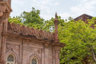 Chennai, Tamil Nadu, Hindistan - 02.07.2025: Sivri çatılı ve önünde yeşil bir ağaç olan bir bina. Binanın bir sürü penceresi var. Chennai 'de.