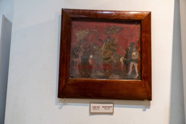 Chennai, Tamil Nadu, Hindistan - 02.07.2025: Bir çerçevedeki insanların resmi. Çerçeve kahverengi. Resim beyaz bir duvarda. Chennai 'de.