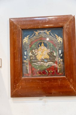 Chennai, Tamil Nadu, Hindistan - 02.07.2025: Üzerinde altın ve mavi elbiseli bir kadının resmi olan ahşap bir çerçeve. Kadın bir kuşun üzerinde oturuyor. Chennai 'de.