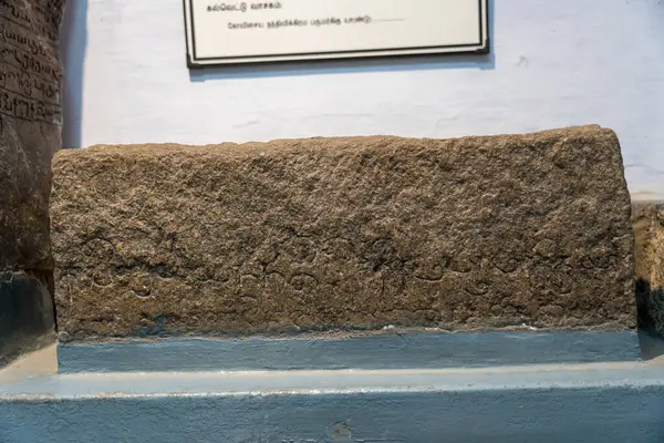 Chennai, Tamil Nadu, Hindistan - 02.07.2025: Üzerinde yazı olan bir taş levha. Yazı yabancı bir dilde yazılmış. Levha mavi bir yüzeyde. Chennai 'de.