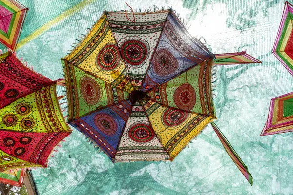 Chennai, Tamil Nadu, Hindistan - 02.07.2025: Tavandan renkli bir şemsiye sarkıyor. Şemsiye çok renkli ve bir deseni var. Chennai 'de.