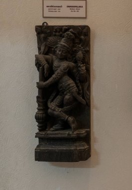 Chennai, Tamil Nadu, Hindistan - 02.07.2025: Sopa tutan bir adamın heykeli. Heykel bir duvarda. Chennai 'de.