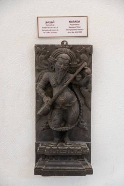 Chennai, Tamil Nadu, Hindistan - 02.07.2025: Telli enstrüman tutan bir adamın heykeli. Heykel beyaz arka planda. Chennai 'de.