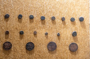 Chennai, Tamil Nadu, Hindistan - 02.07.2025: Duvarda bir sıra bozuk para. Bozukluklar farklı boyutlarda ve renklerde. Chennai 'de.