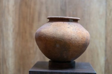 Chennai, Tamil Nadu, Hindistan - 02.07.2025: Kahverengi bir vazo ahşap bir standın üzerinde duruyor. Vazo çamurdan yapılmıştır ve kahverengi bir renge sahiptir. Chennai 'de.