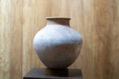 Chennai, Tamil Nadu, Hindistan - 02.07.2025: Ahşap bir masanın üzerinde bir vazo duruyor. Vazo kahverengi ve beyazdır. Chennai 'de.