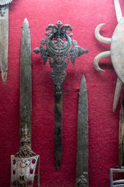 Chennai, Tamil Nadu, Hindistan - 02.07.2025: Kırmızı zemin üzerinde bir kılıç sergilenmektedir. Kılıç siyah ve üzerinde haç var. Chennai 'de.