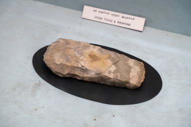 Chennai, Tamil Nadu, Hindistan - 02.07.2025: Bir müzede taş bir alet sergileniyor. Taş alet siyah bir üste. Chennai 'de.