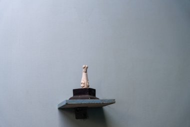 Chennai, Tamil Nadu, Hindistan - 02.07.2025: Küçük beyaz bir köpek heykeli bir rafta duruyor. Rafta bir duvar var. Chennai 'de.