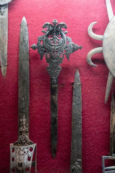 Chennai, Tamil Nadu, Hindistan - 02.07.2025: Kırmızı zemin üzerinde bir kılıç sergilenmektedir. Kılıç siyah ve üzerinde haç var. Chennai 'de.