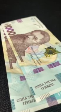 Sinematik çekim: Erkekler Ukrayna 'nın parasının 1000 hryvnia değerinde olduğunu düşünürler. Kişi banknotları sayar. Adam bir tomar para sayıyor. Paralı insan elleri.