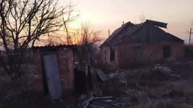 Donetsk bölgesi, Ukrayna: Rusya 'nın Ukrayna' da bombardımandan sonra harap olmuş iki katlı bir yerleşim yeri olan Ukrayna 'ya karşı savaşı ön planda bir çocuk salıncağı var