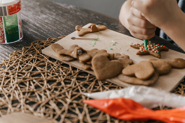 Руки, украшающие печенье глазурью на праздник 