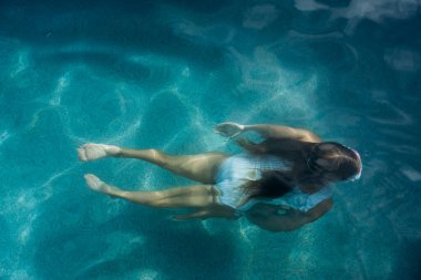 Girl in the pool on a sunny day.  clipart