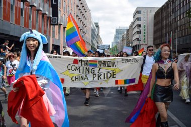 Berlin, Almanya - 23 Temmuz 2023: Christopher Street Day Berlin. Gay Gururu, Gurur Yürüyüşü. LGBTQ + tanıtımında gökkuşağı bayrağı ve protesto afişi taşıyan Çinli kadınlar. Tuhaf bir kavram.