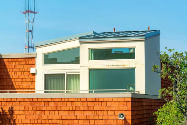 turuncu ve beyaz sıva ve ahşap kaplı ev folliage ve sutro kule arka plan mavi gökyüzü gün ortasında güneş ile ilgili ayrıntılı çekim