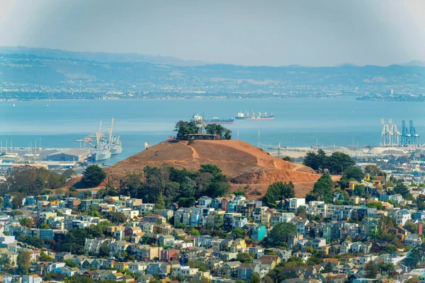 San Francisco şehir merkezindeki tepe. Mahalleleri, evleri ve dağların eteklerine yakın binaları var. Mavi okyanus arka planında beyaz gökyüzü ve tekneler ve deniz arka planında nakliye gemileri.