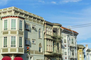 San Francisco şehir merkezinde, gökyüzü mavi arka planlı, öğle güneşinde modern ev cepheleri. Mahallede ya da şehirde sokak lambaları ve kırmızı tenteleri olan.