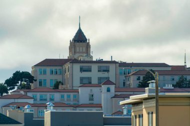 Gün sonunda San Francisco şehir merkezinde gece yarısı gölgesinde binalar var. Arka planda da bir kule var. Şehir merkezinde ya da metropolde gün batımında bulutlu ya da sisli gökyüzü.