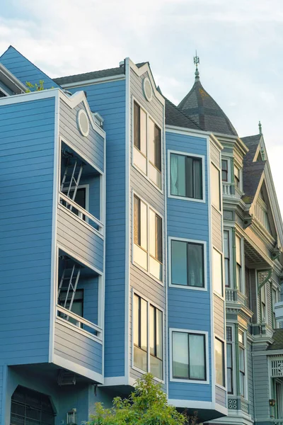 Ahşap ya da ahşap kaplamalı modern apartman daireleri ya da dekoratif pencereli ahşap bina ve öğleden sonra güneşli evlerin çatıları. Şehrin banliyölerinde ya da şehir merkezinde..