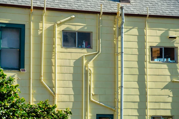 Gelbe Hausfassade Mit Strom Und Wasserleitungen Auf Der Gebäudeseite Mit — Stockfoto