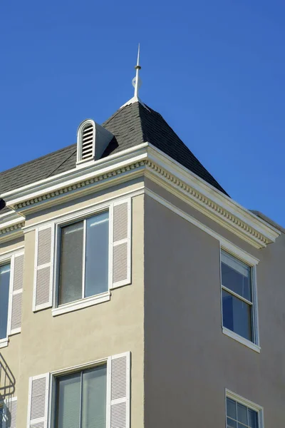 Beżowy Budynek Sztukaterią Brązowym Dachem Białą Farbą Akcentową Wokół Okien — Zdjęcie stockowe