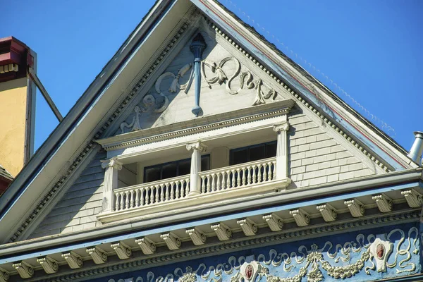 stock image Decorative hidden balcony with victorial style and fancy facade on exterior with gable roof and blue sky background in the neighborhood. In the downtown city or front yard view in the metropolis.