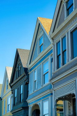 Ahşap kaplı evler kahverengi, mavi ve bej sürahiler ve açık mavi gökyüzü ve görünür pencereleri olan güneşli kiremitli çatılar. Tarihi San Francisco California 'da öğleden sonra.