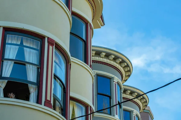 Row of circular building facades on house or home in the neighborhood or in a suburban area of the downtown city in shade. Late in the afternoon with cloudy blue sky background midday metropolis.