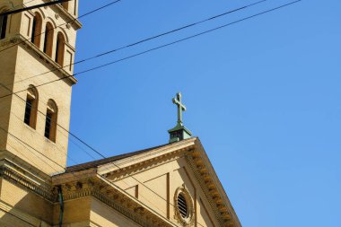 Şehir merkezinde yeşil bakır çatılı, çift gable çatısı olan turuncu sıva binanın yakın görüntüsü. Kopya alanı olan şehirde mavi gökyüzü arka planı mahallede..