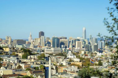San Francisco 'nun tarihi bölgelerindeki şehir merkezine doğru öğleden sonra güneşi altında bir bakış açısı. Mahallede gökdelenleri ve mavi gökyüzü arkaplanı olan birçok bina var..