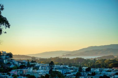 San Francisco 'nun şehir merkezindeki gölgeli semtlerde günbatımı tepeleri var. Kaliforniya 'da günün ilerleyen saatlerinde evler ve evlerle.