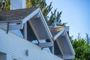 Çift gable stili pencere duvarlı çatılar arka bahçeli beyaz sıva evler ve mavi eğimli gökyüzü arkaplanı. Mahallenin banliyösünde, öğleden sonra gölgesinde.