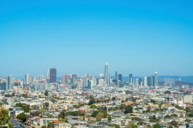 Şehir merkezindeki gökdelenler San Francisco California 'nın tarihi bölgelerinde genişleyen banliyö ve kentsel mahallelerle birlikte. Şehir merkezi puslu mavi ve beyaz gökyüzü ile.