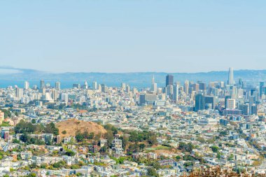 San Francisco şehir merkezinin güneşli panoramik manzarası tepeler, ağaçlar, binalar evleri, gökyüzü kazıyıcıları, okyanus manzarası ve arka plan ve mavi ve beyaz gökyüzü.
