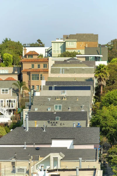 San Francisco civarındaki bir tepenin üstündeki modern ev çatıları mavi ve beyaz gökyüzü ile güneşli California 'nın göbeğinde. Kenar mahallelerde gün ortasında baca ve çok renkli çatılar..