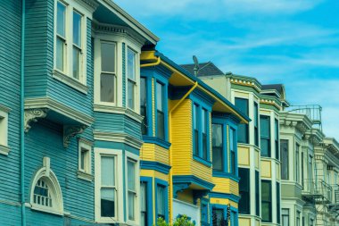 San Francisco şehir merkezinde ve mahallede renkli ve dekoratif ev cepheleri. Öğleden sonra gölgesinde, mavi gökyüzü arka planıyla caddenin ön bahçesinde..