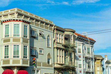 San Francisco şehir merkezinde, gökyüzü mavi arka planlı, öğle güneşinde modern ev cepheleri. Mahallede ya da şehirde sokak lambaları ve kırmızı tenteleri olan.