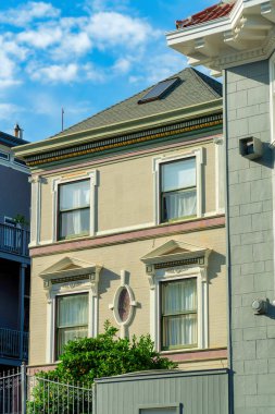 Krem renkli ön cepheli, sıva duvarlı, kahverengi çatılı, öğlen güneşinde beyaz pencere aksanlı boyalı. San Francisco şehir merkezinde, mavi gökyüzü geçmişiyle California 'da..
