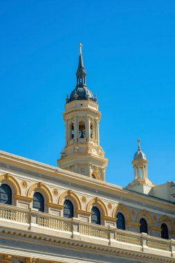 Kilise kulesi ve çevreleyen bina çatısı dekoratif malzemelerle ve mavi kuleli boya ve açık bir arka plan. Öğleden sonra güneşinde şehirde ya da şehir merkezinde..