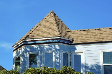 San Francisco 'nun tarihi bölgelerindeki gölgeli mahallede mavi sıva dış görünüşlü ev cephesi. Taretteki açık kahverengi kiremitler ya da banliyölerdeki kule tarzı binalar.