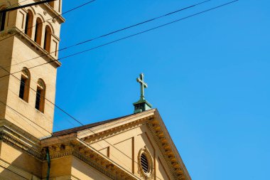Şehir merkezinde yeşil bakır çatılı, çift gable çatısı olan turuncu sıva binanın yakın görüntüsü. Kopya alanı olan şehirde mavi gökyüzü arka planı mahallede..