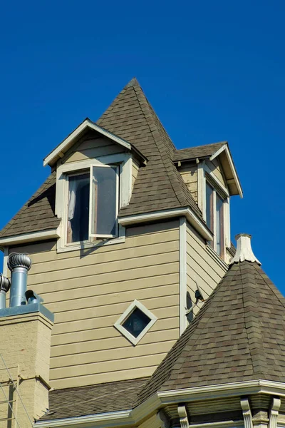 木制或木制房屋或家庭与米色木制镶板和深褐色屋顶与瓷砖和可见的开放窗口与烟囱 清晰的蓝色背景 附近有白色口音油漆 — 图库照片