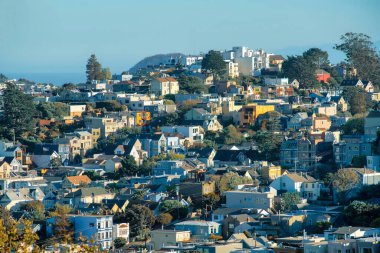 San Francisco California 'nın şehir merkezindeki tarihi bölgelerinde modern bir mahalle. Komşu binalarda evleri var. Öğleden sonra güneşinin altında mavi gökyüzü ve şehrin ön ve arka bahçeleri.