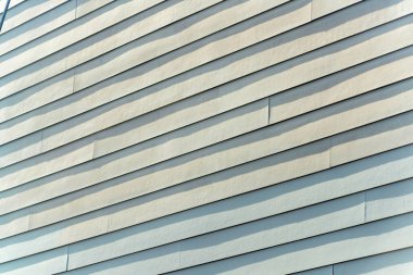 Yatay olarak yontulmuş ahşap ya da kereste duvarın dış yüzeyinde şehirdeki ya da endüstriyel ya da kentsel alandaki gölgeler var. Öğleden sonra gölgesinde alçak açıda.