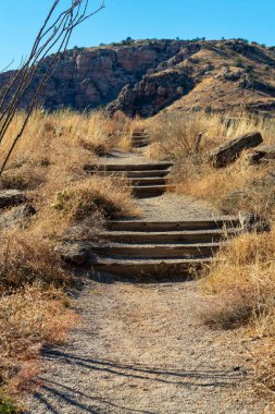 Hiking trail or path for recreation and exercise in the great outdoors in arizona in tuscon and phoenix for adventurers. Late in the day with mountain background and trees and natural grasses.
