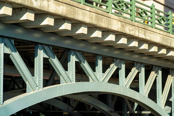 車両の輸送のためのセメントや木製の締結材料と金属ビームや極と大規模なアーチ橋 川を渡るために緑の手すりと橋の上を歩く人々 — ストック写真