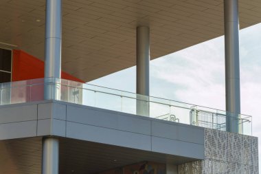 Commercial business in outdoor mall and shopping center with decorative balcony for diners and shoppers to rest and eat. Late afternoon shade with metal exterio and beams with modern roof.