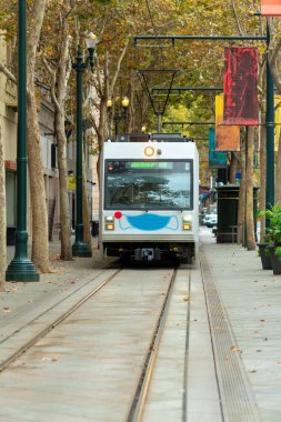 Şehir merkezindeki Silikon Vadisi 'nden San Jose California' ya gelen bir tren var. Öğleden sonra gölgesi, ağaçların oluşturduğu patikalar..