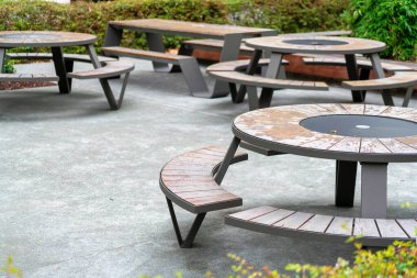 Avluda öğle yemeği masalarının yuvarlak olduğu veranda ve veranda. Şehirde bitki ve çalılar var. Lokantaya yakın ya da insanların yemek yiyip dışarıda dinlenebileceği bir iş yeri..